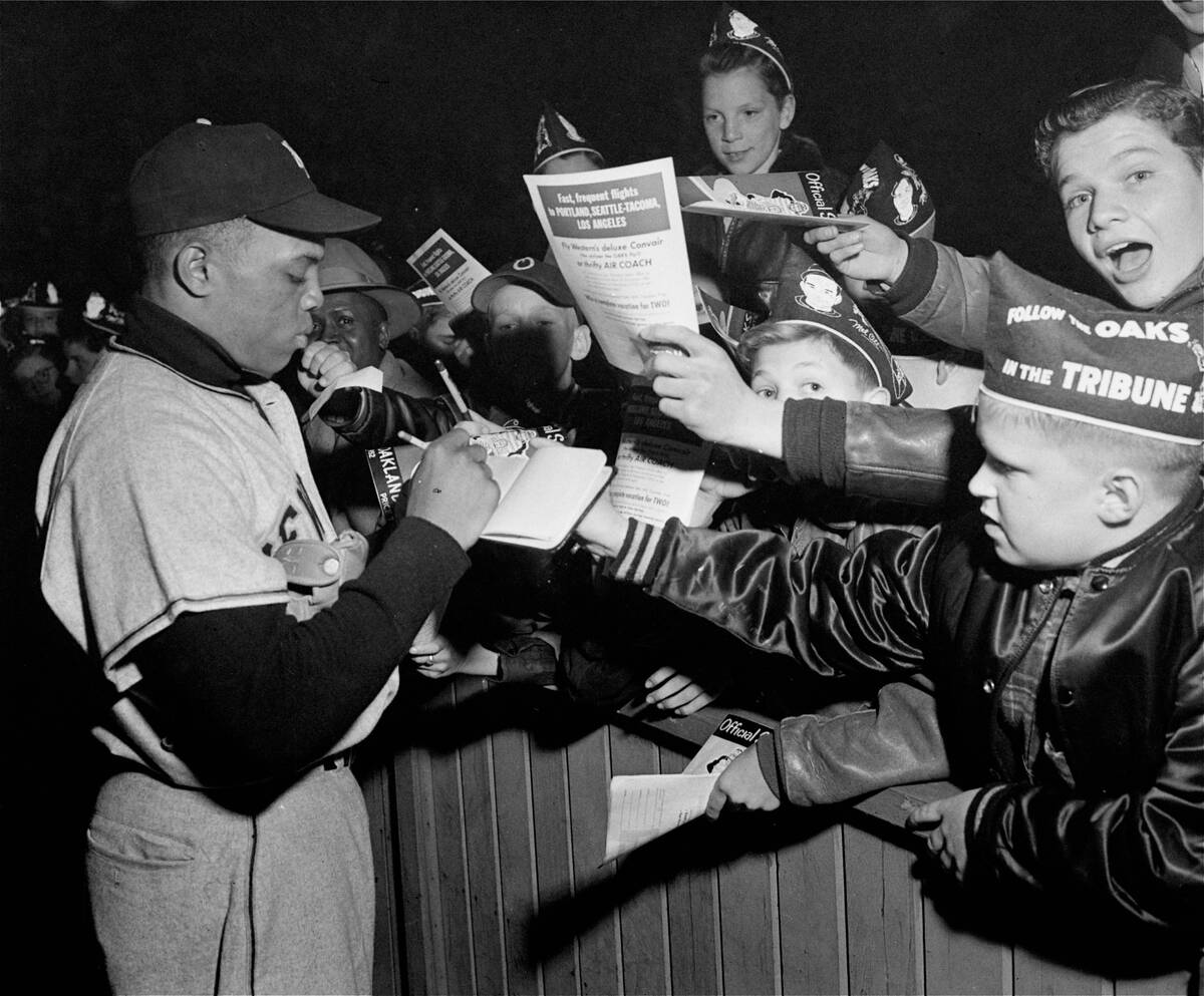 Willie Mays, New York Giant centerfielder, signs autographs at an exhibition game in Oakland, C ...