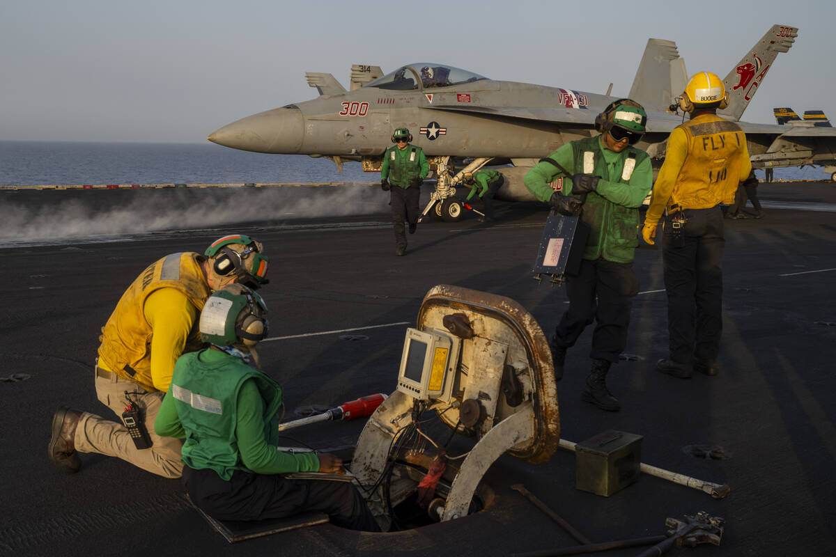 Crew members work during take off operations on the deck of the USS Dwight D. Eisenhower in the ...