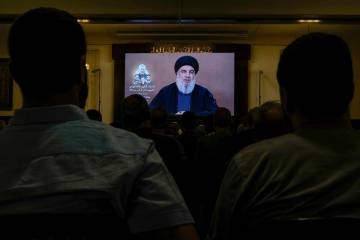 Hezbollah supporters watch a speech given by Hezbollah leader Sayyed Hassan Nasrallah on a scre ...