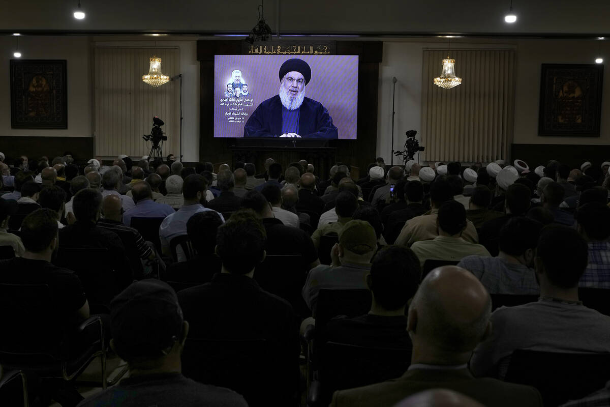 Hezbollah supporters watch a speech given by Hezbollah leader Sayyed Hassan Nasrallah on a scre ...
