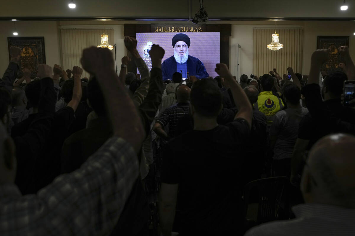 Hezbollah supporters raise their fists and cheer as they watch a speech given by Hezbollah lead ...