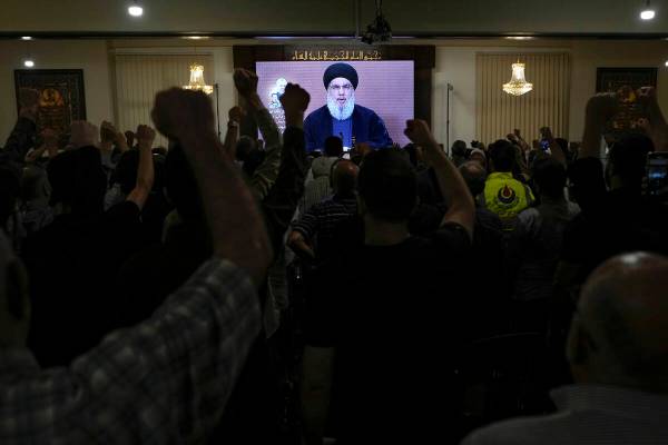 Hezbollah supporters raise their fists and cheer as they watch a speech given by Hezbollah lead ...