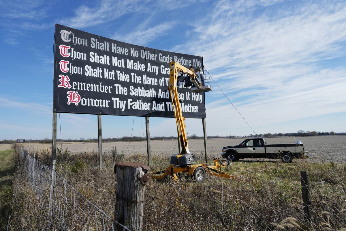 Workers repaint a Ten Commandments billboard off of Interstate 71 on Election Day near Chenowet ...