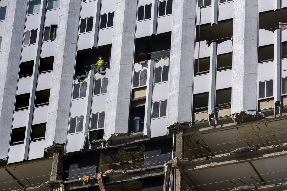 A construction worker looks out of a higher floor of the tower as demolition continues on the T ...