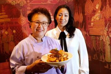 Lotus of Siam chef-owner Saipin Chutima, left, shows a dish of Garlic Prawns with her daughter ...