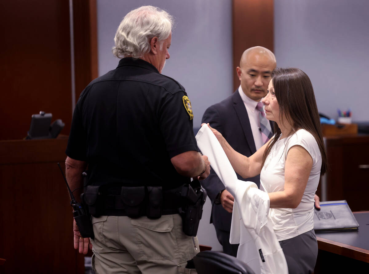 Pamela Bordeaux, 60, right, passes personal belongings to a loved one before being remanded int ...