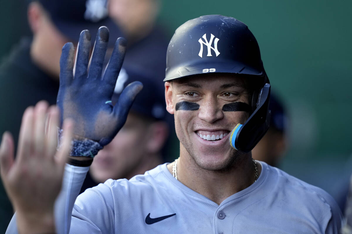 New York Yankees' Aaron Judge celebrates in the dugout after scoring on sacrifice fly hit by An ...