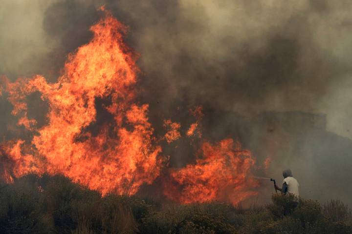 Homeowner Steven Phelps battles the Pinehaven Fire in the Caughlin Ranch area of Reno on Nov. 1 ...