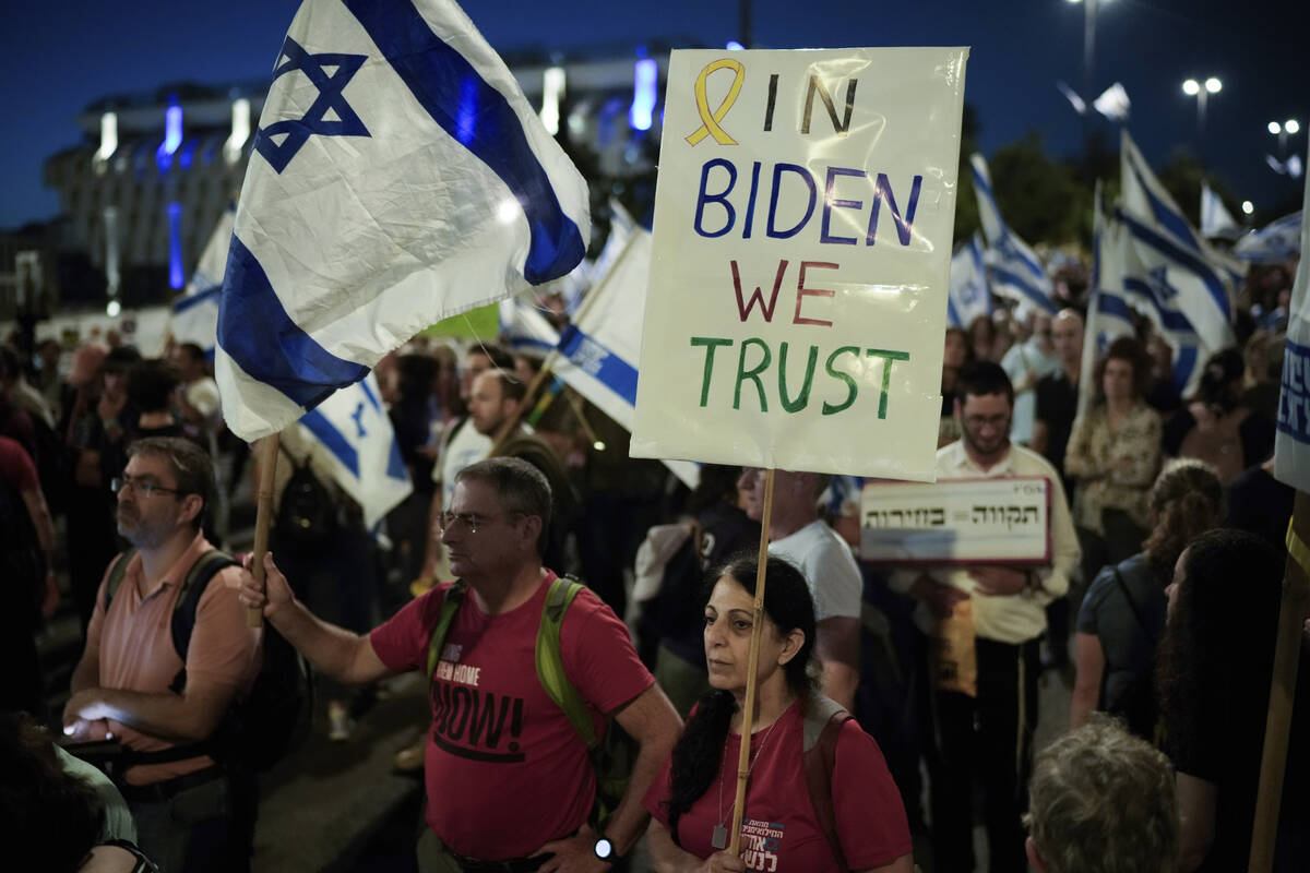 People wave Israeli flags and signs during a protest against Israeli Prime Minister Benjamin Ne ...
