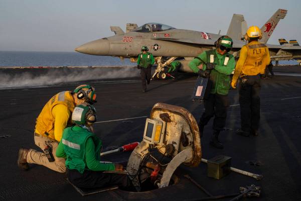 Crew members work during take off operations on the deck of the USS Dwight D. Eisenhower in the ...