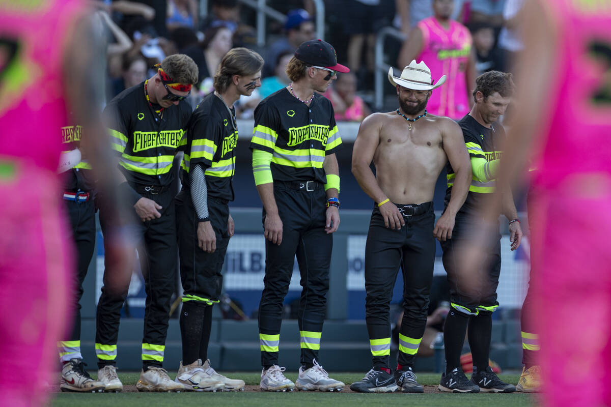 Members of the Firefighters watch as Garrett Declue flexes before the game against the Party An ...