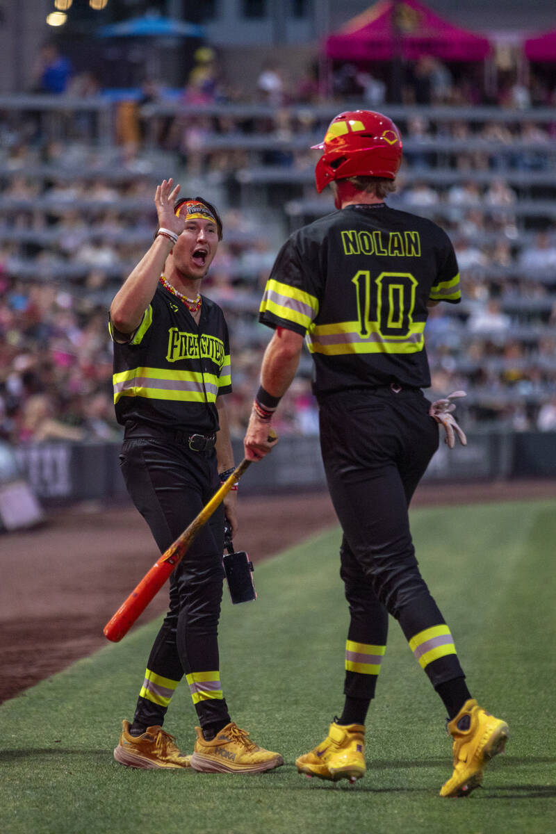 Firefighters’ Christian Dearman, left, high-fives Parker Nolan (10) after scoring a run ...