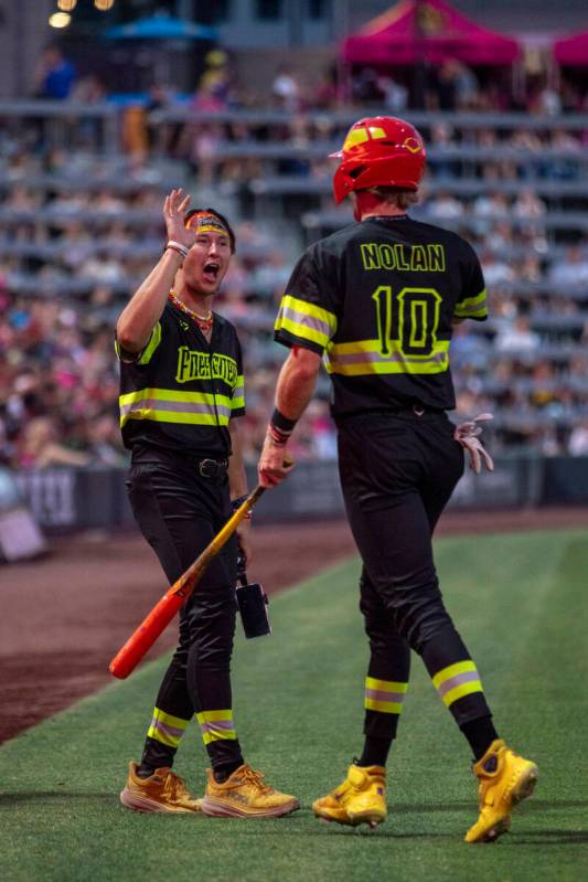 Firefighters’ Christian Dearman, left, high-fives Parker Nolan (10) after scoring a run ...