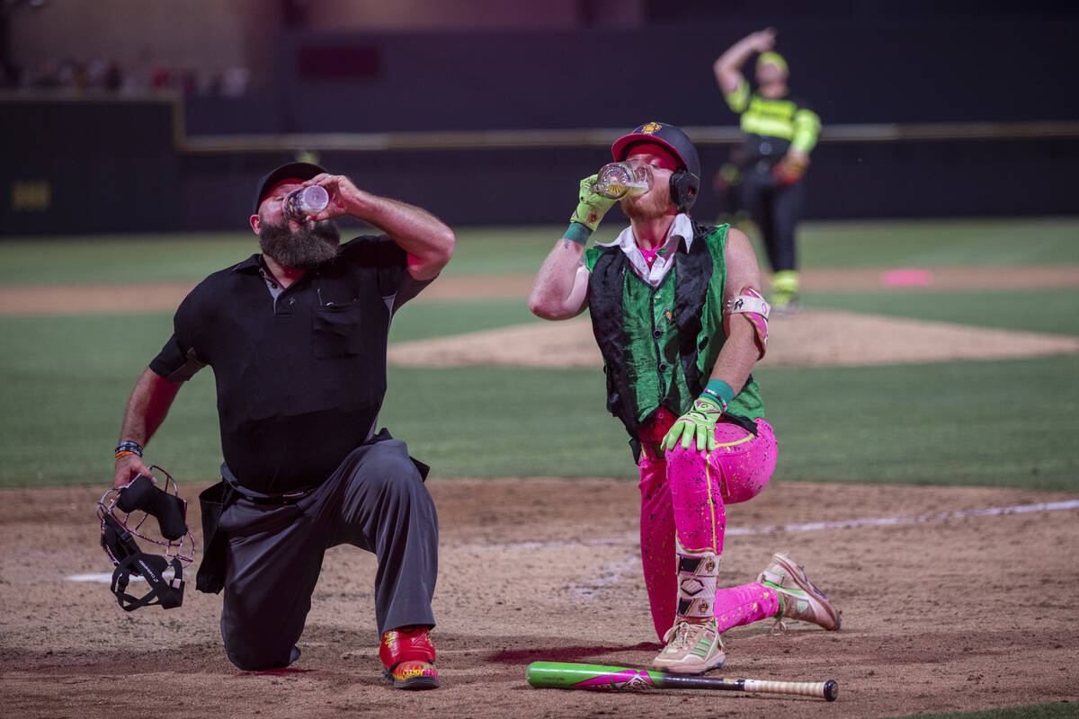 Umpire Vincent “Vinny” Chapman, left, and Party Animals’ Dustin Baber, right, chug glasse ...