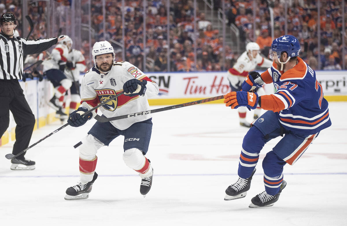 Florida Panthers' Sam Reinhart (13) and Edmonton Oilers' Brett Kulak (27) compete for the puck ...