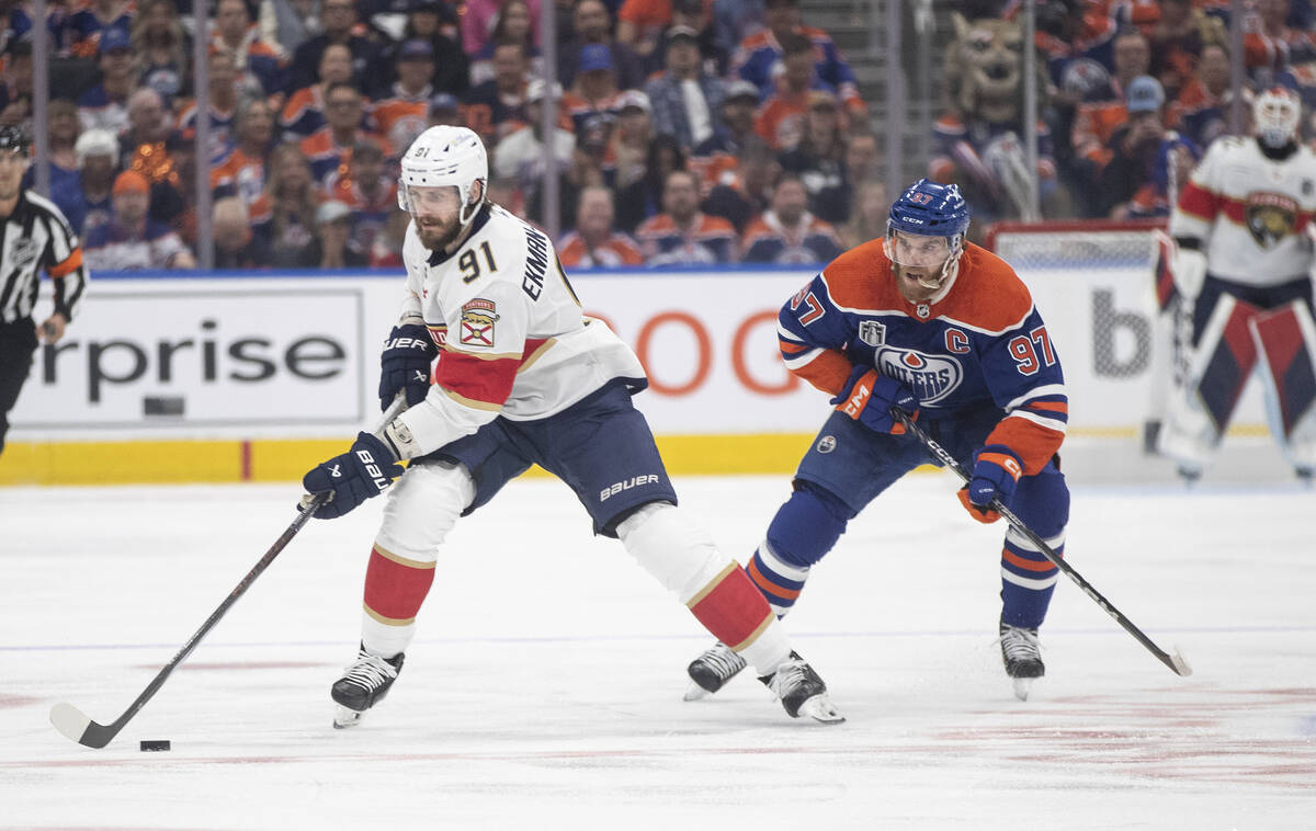 Florida Panthers' Oliver Ekman-Larsson (91) reaches for the puck, next to Edmonton Oilers' Conn ...