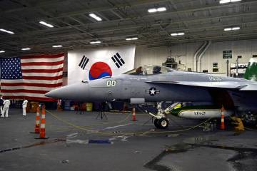 An F-18 fighter aircraft sits in the hanger of the Theodore Roosevelt (CVN 71), a nuclear-power ...