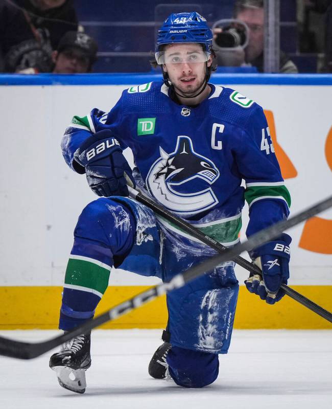 Vancouver Canucks' Quinn Hughes pauses after being checked to the ice during the third period o ...