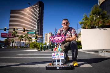 Chris Raley, of Route 9 Signs, based out of Fresno, Calif, poses with his miniature replica of ...
