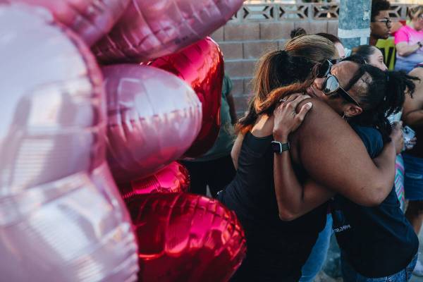 Mourners hug during a vigil for Kayla Harris, who was killed in a quintuple homicide on June 24 ...