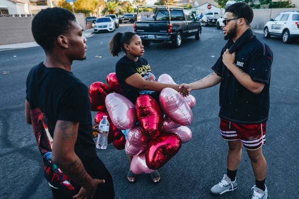 Jalen Simmons, right, Kayla Harris’ older brother, shakes hands with a mourner during a ...