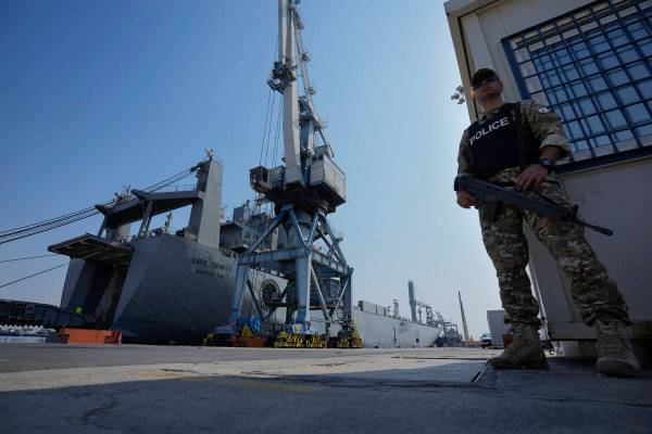 A Cypriot military police officer stands guards next of the docked U.S ship carrying Gaza aid, ...