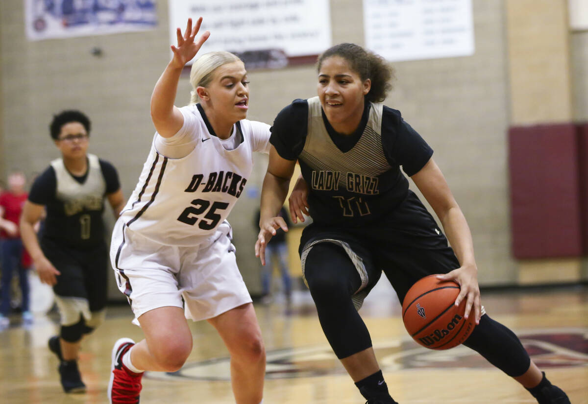 Spring Valley's Kayla Harris (11) drives against Desert Oasis' Melissa Simmons (25) during a ba ...