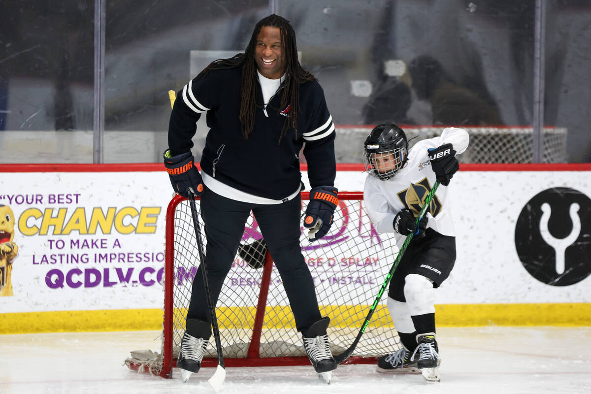 George Laraque, a former professional hockey player, mans a goal while young players take shots ...