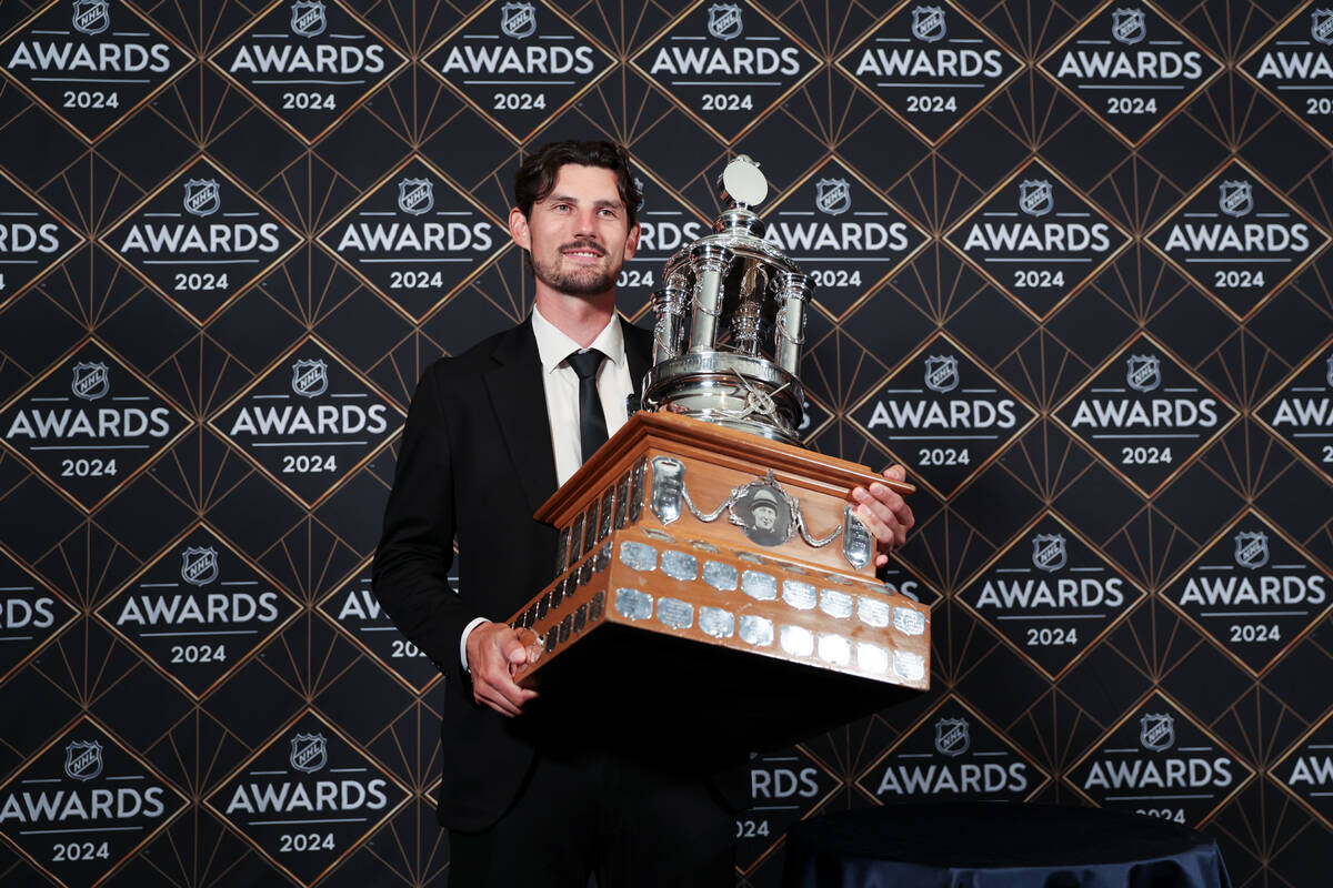 Winnipeg Jets goaltender Connor Hellebuyck holds the Vezina Trophy after winning the honor duri ...