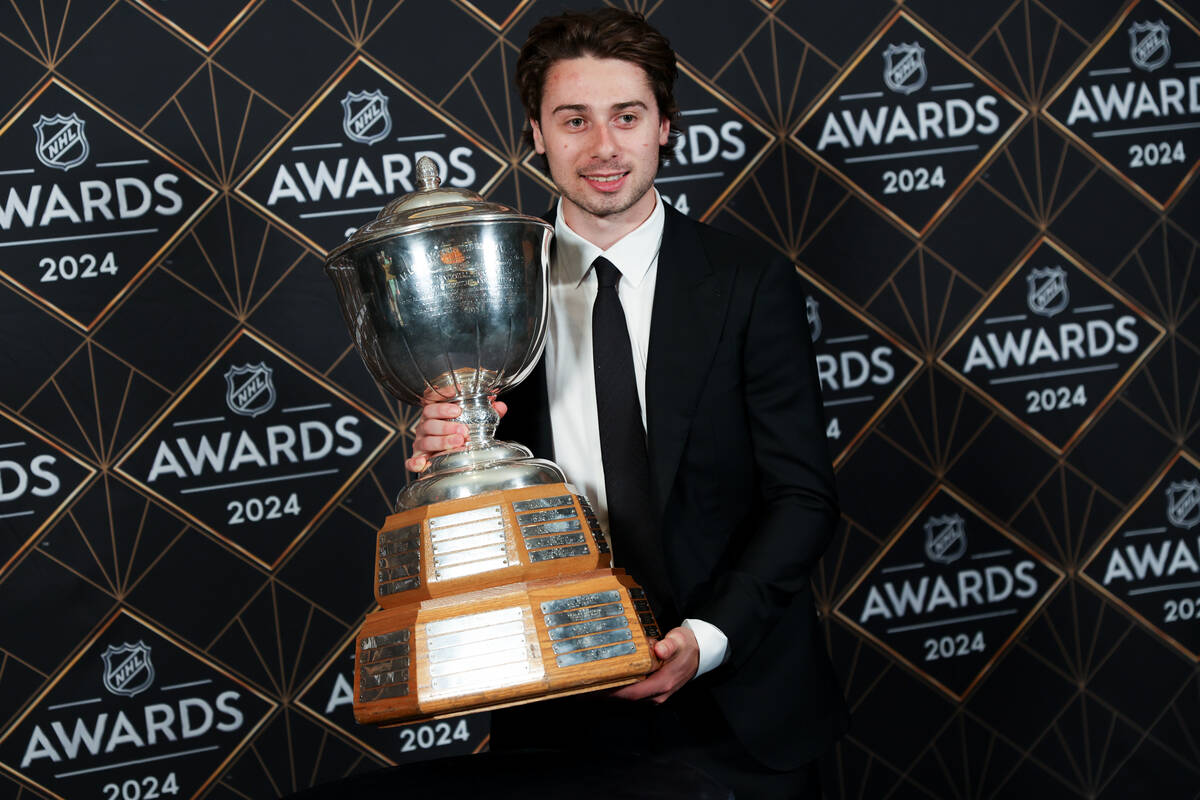 Vancouver Canucks defenseman Quinn Hughes holds the Norris Trophy after winning the honor durin ...