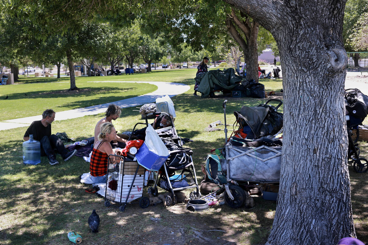 People take shelter from the sun with their belongings at Justice Myron E. Leavitt and Jaycee C ...