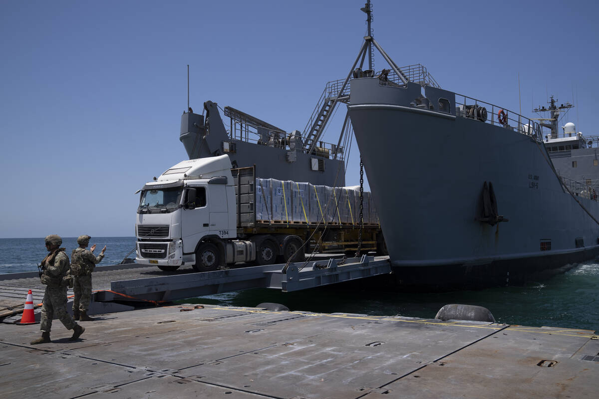 A U.S. Army soldier gestures as trucks loaded with humanitarian aid arrive at the U.S.-built fl ...