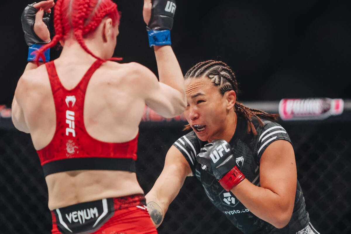 Michelle Waterson-Gomez, right, throws a punch at Gillian Robertson during their strawweight bo ...