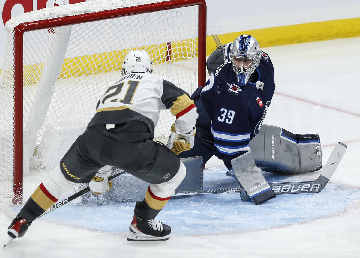 Vegas Golden Knights' Brett Howden (21) scores against Winnipeg Jets goaltender Laurent Brossoi ...