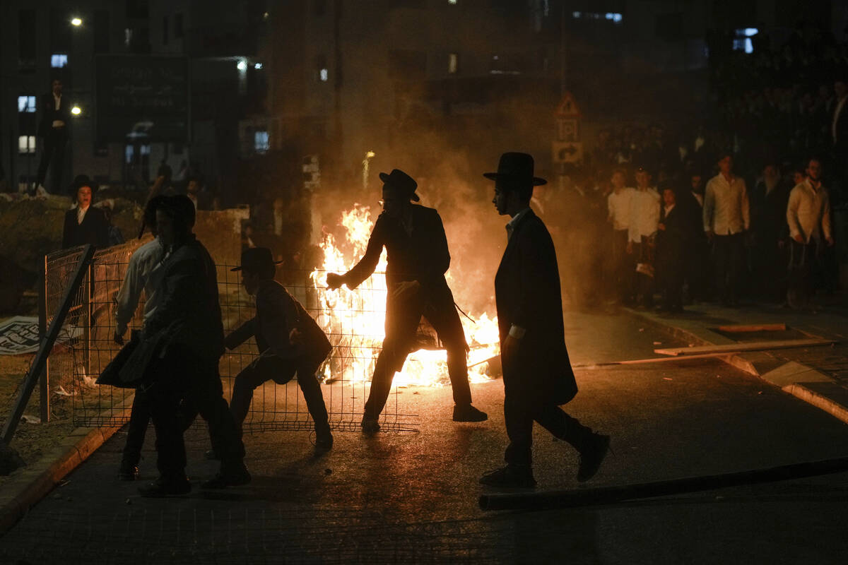 Ultra-Orthodox Jewish men burn trash during a protest against army recruitment in Jerusalem on ...