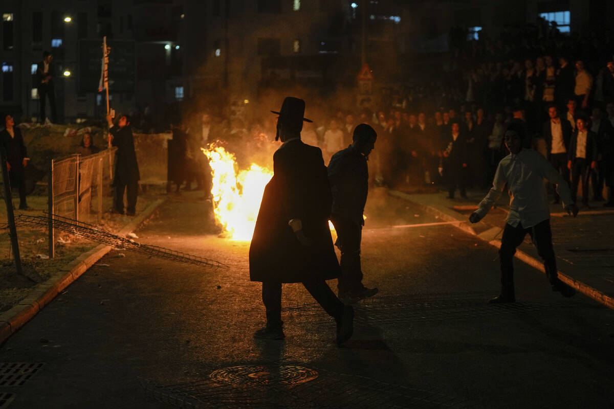 Ultra-Orthodox Jewish men burn trash during a protest against army recruitment in Jerusalem on ...