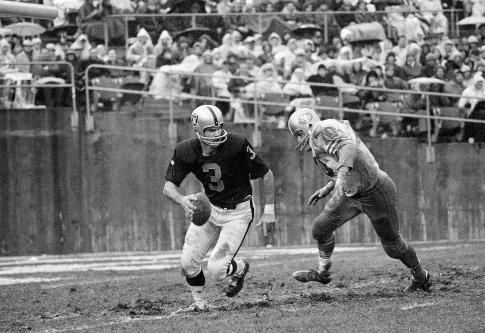 FILE - Oakland Raiders quarterback Daryle Lamonica (3) hustles to get out of the path of Charle ...
