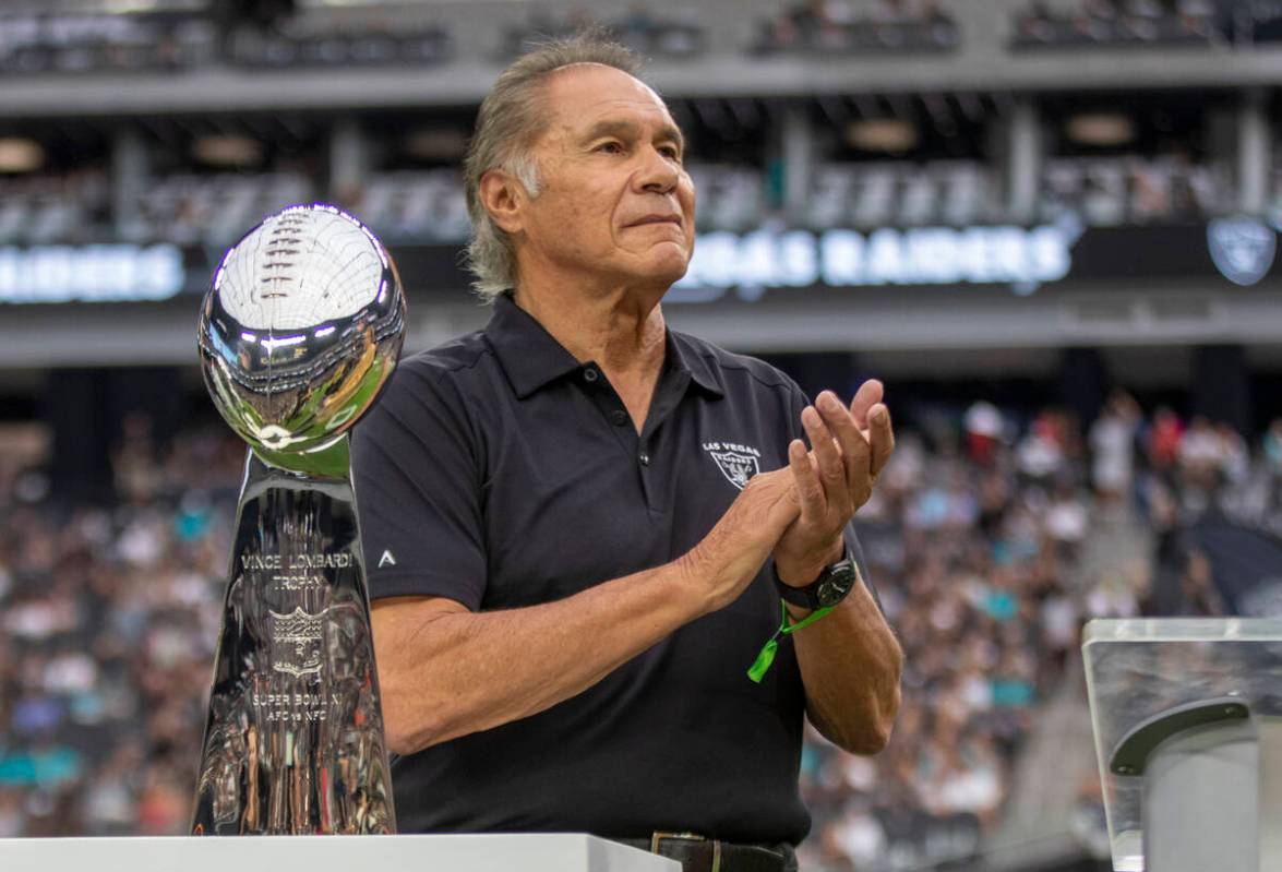 Former Raiders quarterback Jim Plunkett applauds during Tom Flores’ Hall of Fame ring ce ...