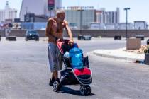 A homeless man wheels a jug of water to his encampment along East Washington Avenue in Las Vega ...