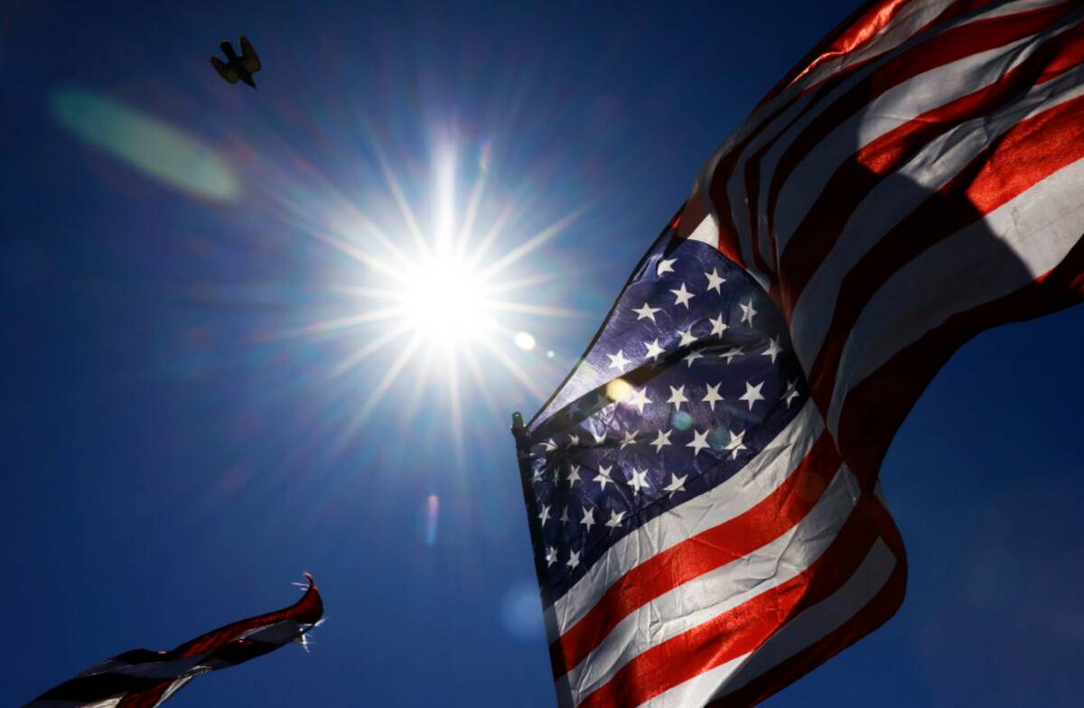 The afternoon sun light rays pierce through American flags, on Monday, July 1, 2024, in Las Veg ...