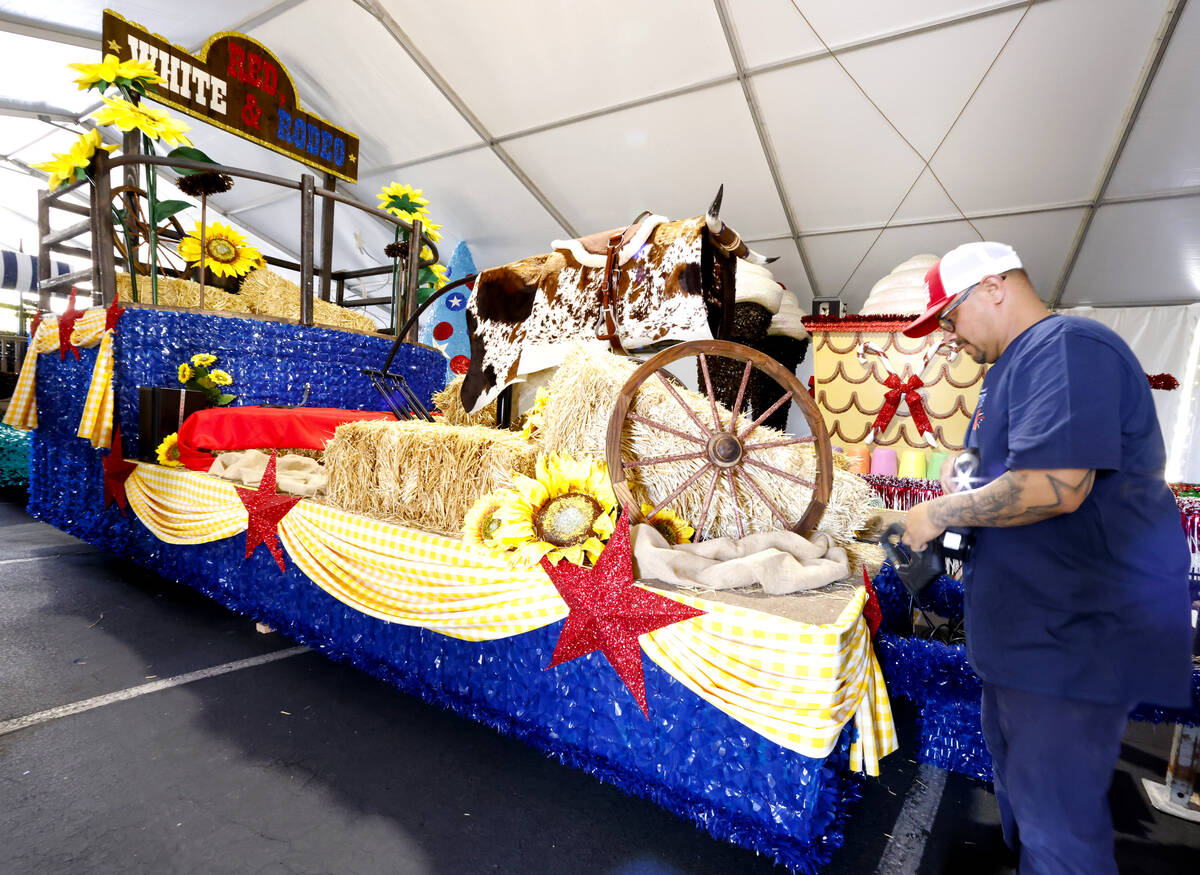 Ricardo Sandoval, a volunteer, decorates the “Red White and Rodeo” float, to be f ...