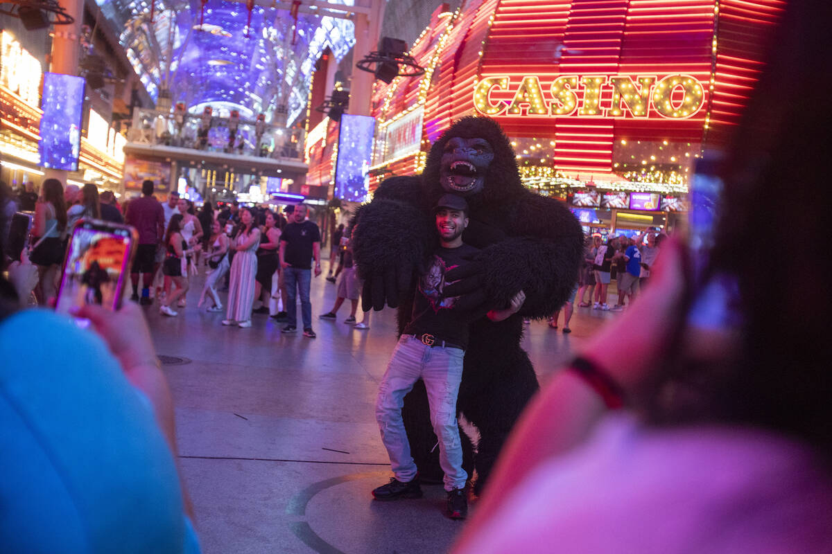 Tourists dance with a gorilla busker at the Fremont Street Experience Monday, July 1, 2024, in ...