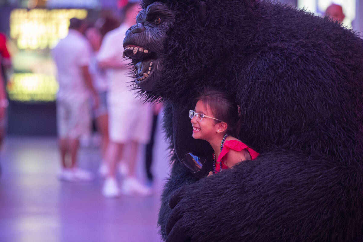 Tourists dance with a gorilla busker at the Fremont Street Experience Monday, July 1, 2024, in ...