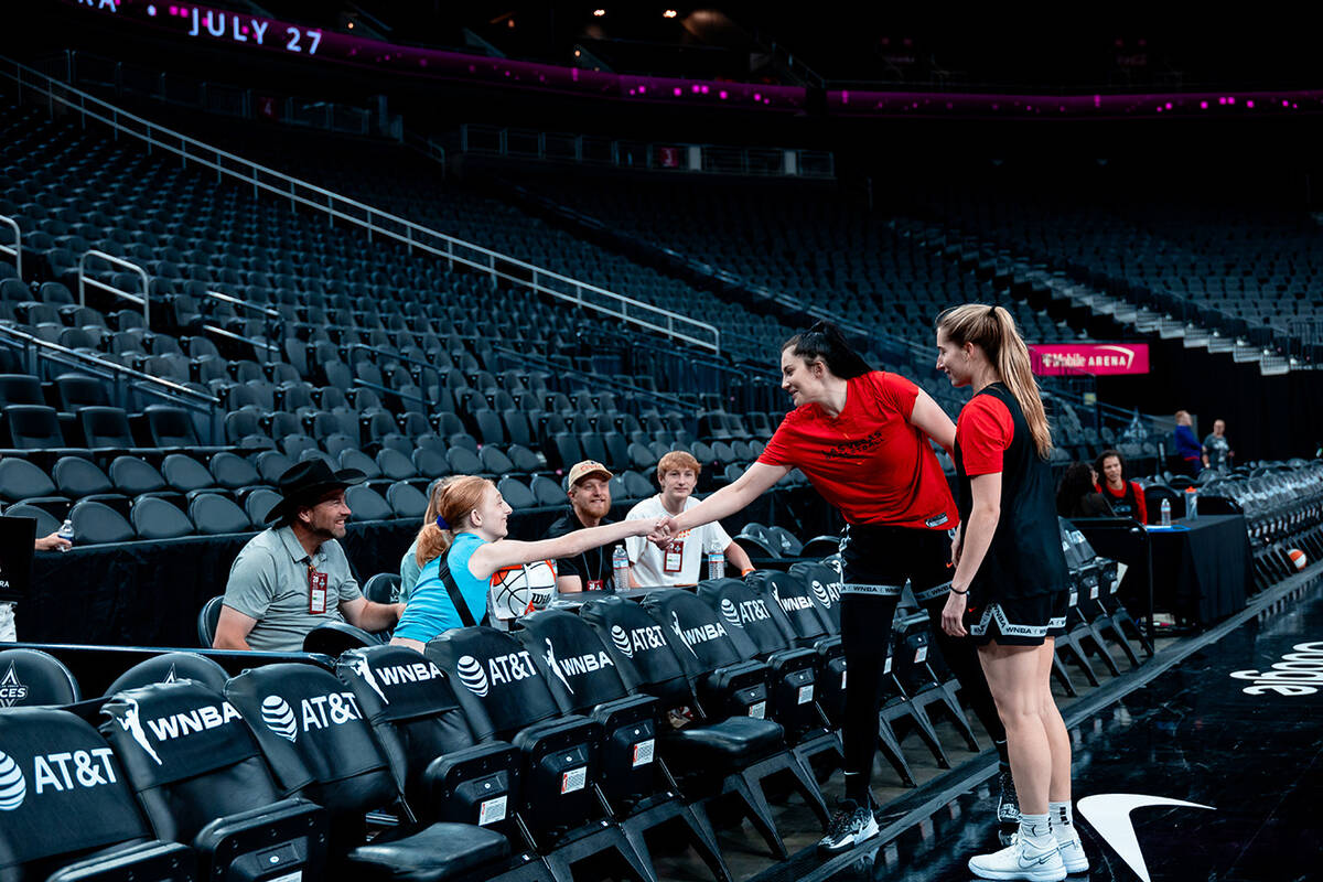 Las Vegas Aces reserve center and Iowa alum Megan Gustafson shakes Bailey Lux's hand during pra ...