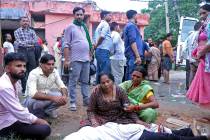 Women mourn next to the body of a relative outside the Sikandrarao hospital in Hathras district ...