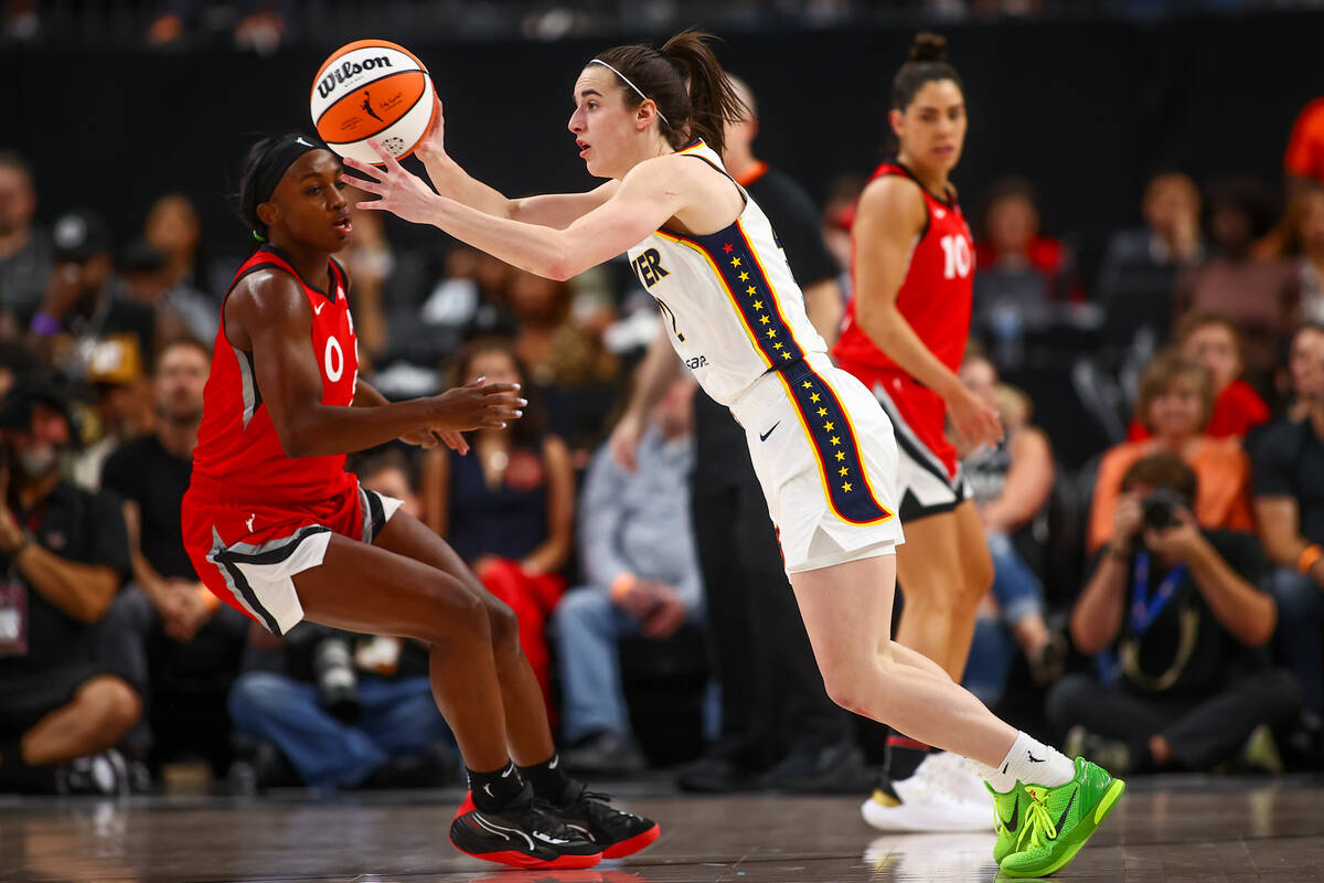 Indiana Fever guard Caitlin Clark (22) passes while Las Vegas Aces guard Jackie Young (0) pivot ...