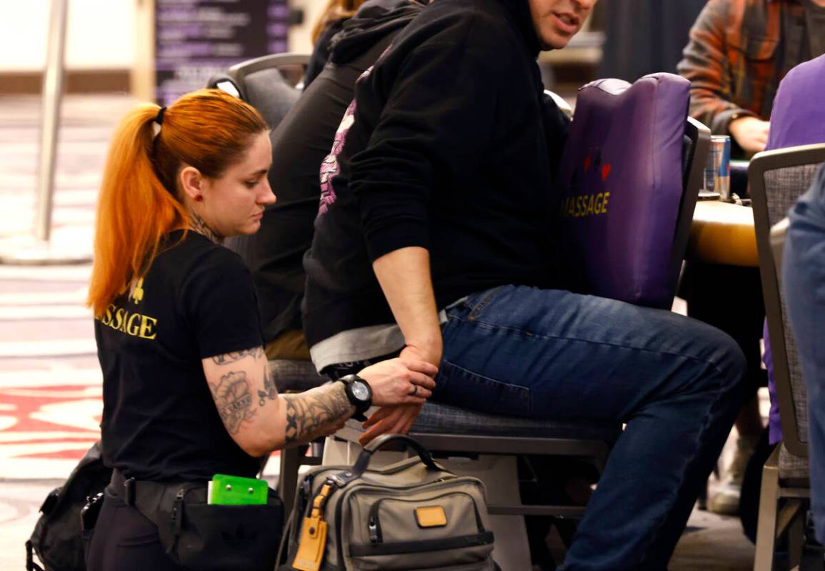 A massage therapist gives a poker player a massage during the first day of the World Series of ...