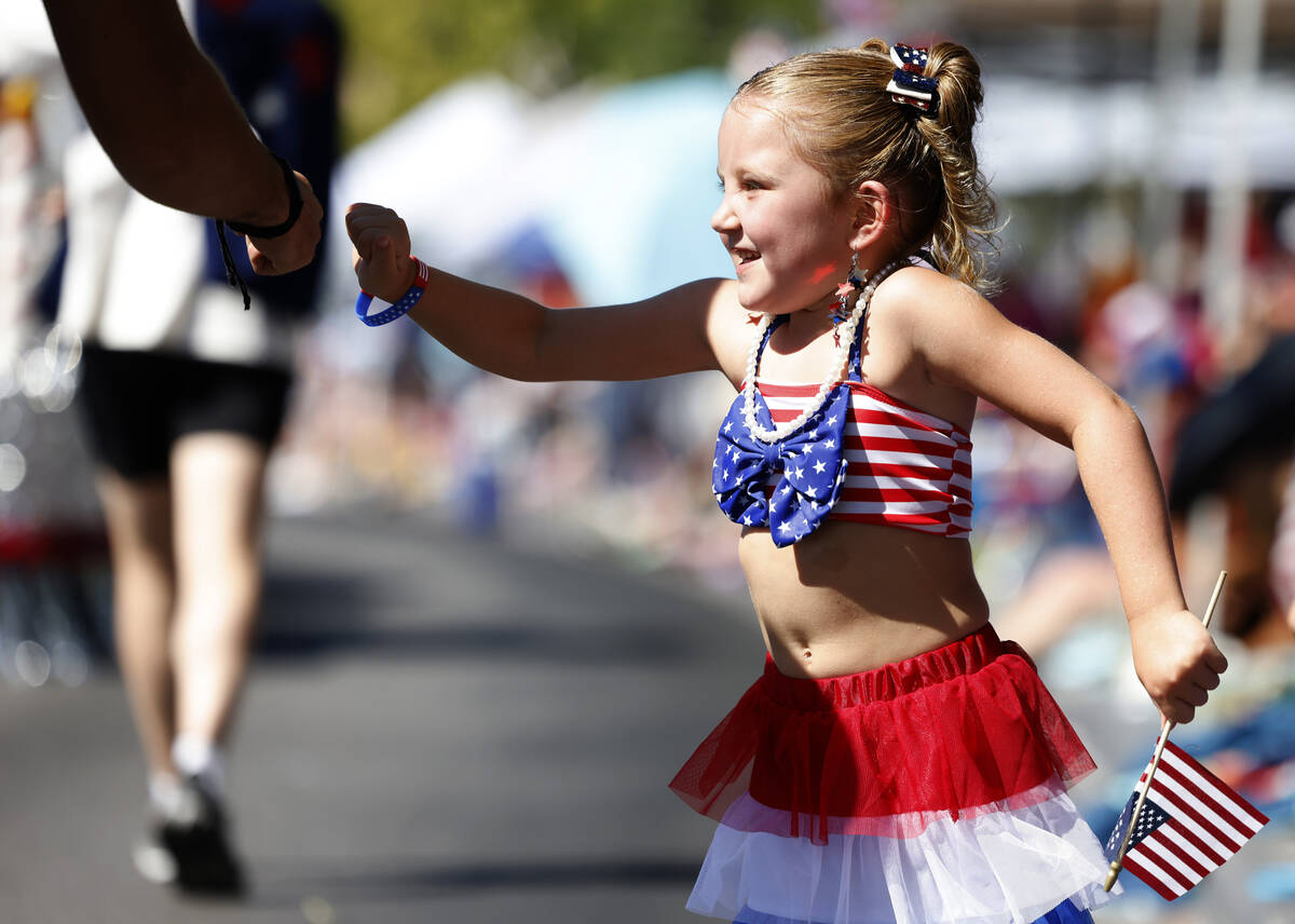 Scarlett Legrow exchanges fist bumps with a parade participant during the annual Summerlin Coun ...