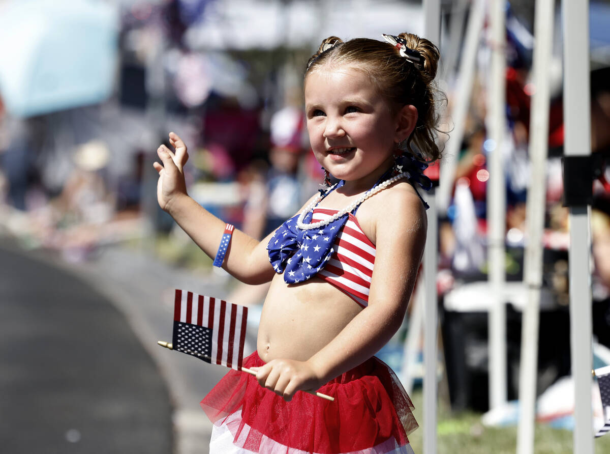 Scarlett Legrow waves as she watches the annual Summerlin Council Patriotic Parade, on Thursday ...