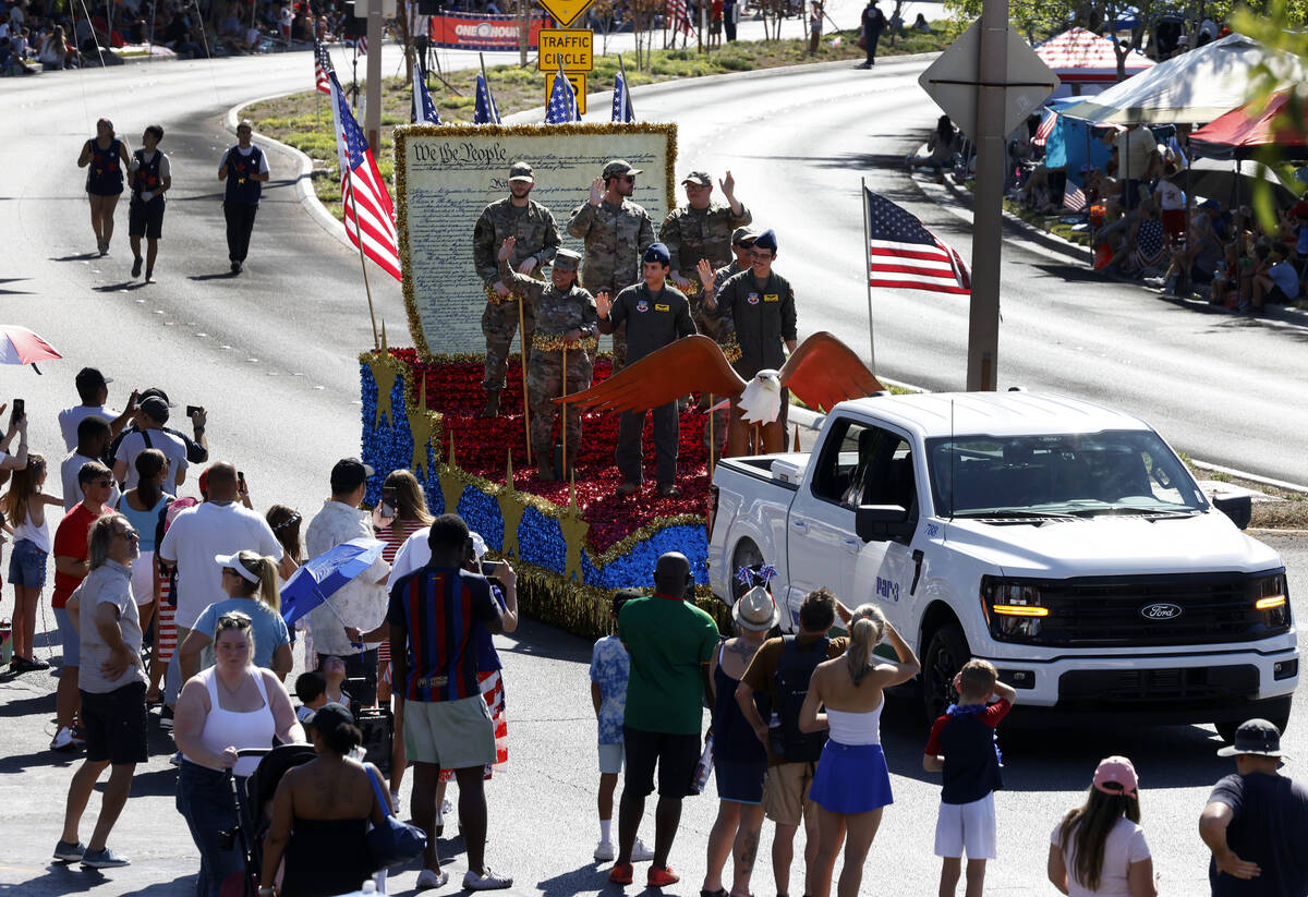 Members of the military wave to the crowd from the All-Star Salute to the Military float during ...